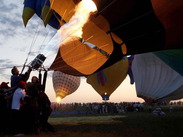 Contestants prepare their hot air balloons during an international hot air balloon festival in Baotou, north China