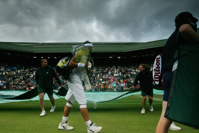 Rafael Nadal leaves the Wimbledon court due to the rain