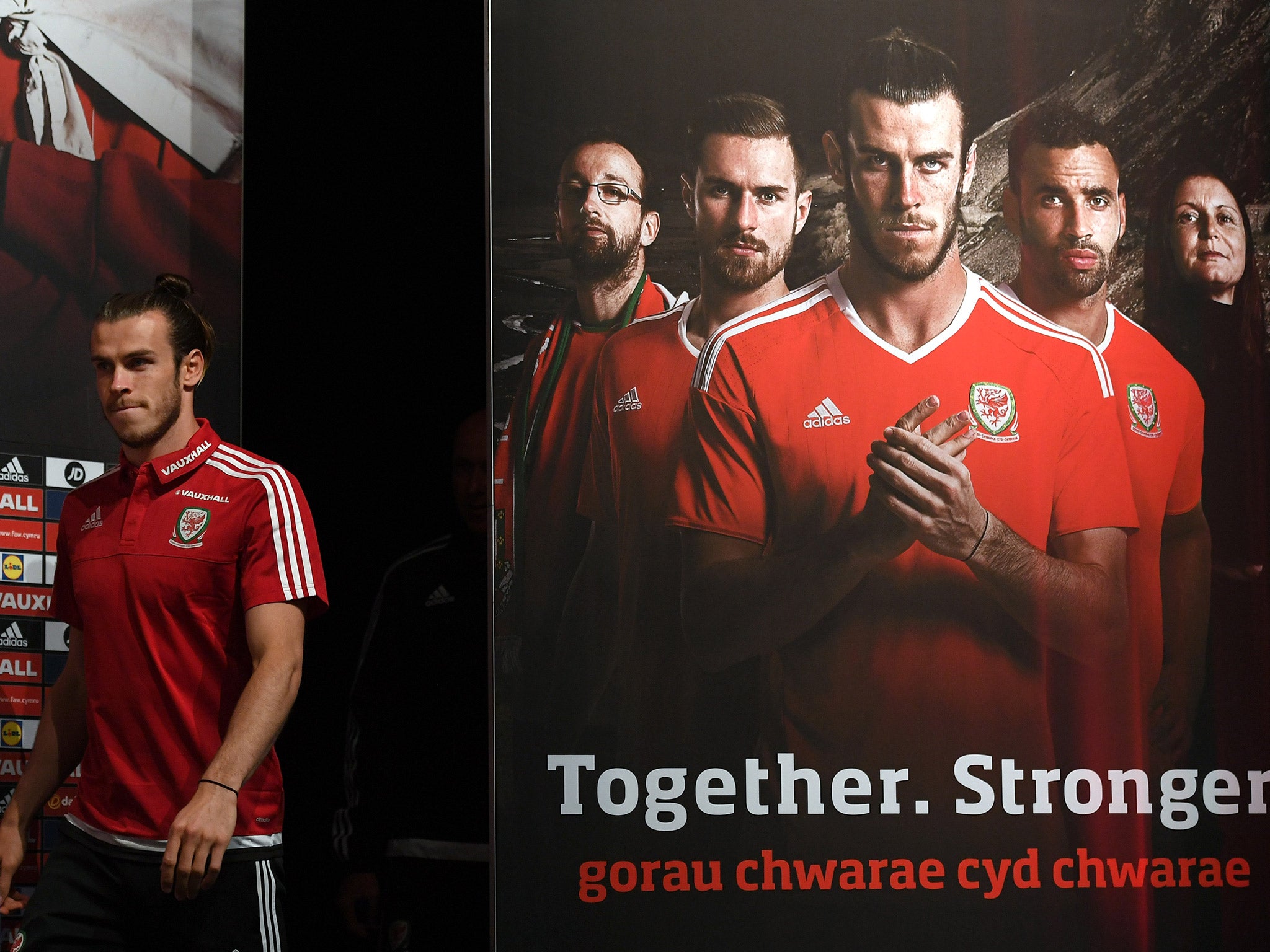 Gareth Bale appears at a press conference in front of a large 'Together. Stronger' poster