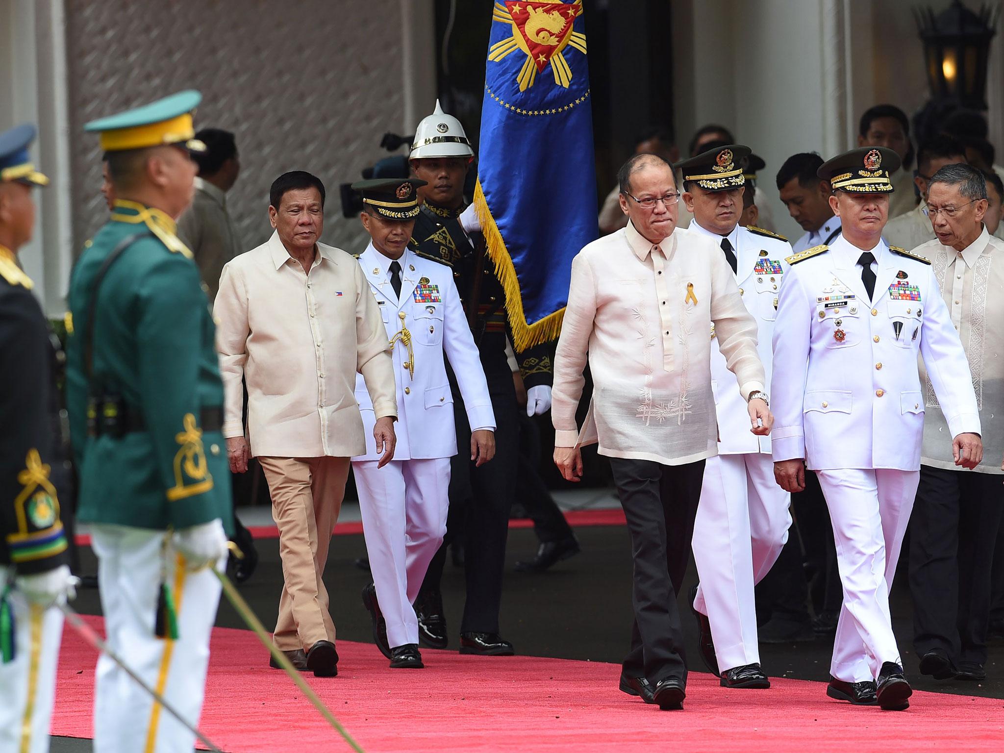 Rodrigo Duterte (left) walks behind outgoing President Benigno Aquino ahead of the swearing-in ceremony at Malacanang Palace in Manila