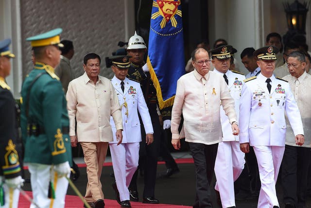 Rodrigo Duterte (left) walks behind outgoing President Benigno Aquino ahead of the swearing-in ceremony at Malacanang Palace in Manila