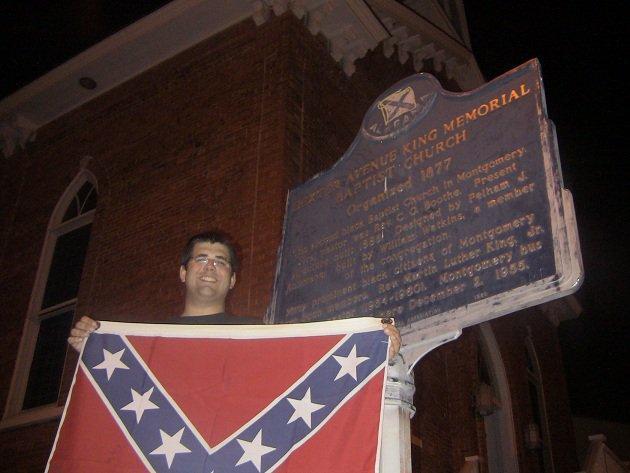 Matthew Heimbach holds up a Confederate flag outside the Dexter Avenue Baptist Church in Montgomery, Alabama, where Martin Luther King Jr planned the Montgomery bus boycott