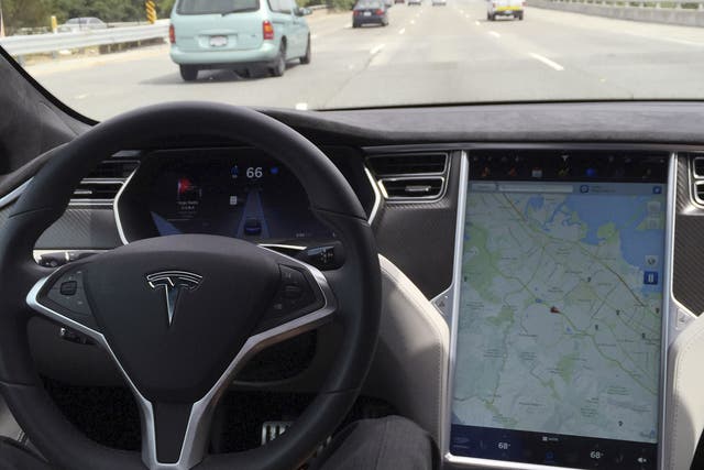 The interior of a Tesla Model S is shown in autopilot mode
