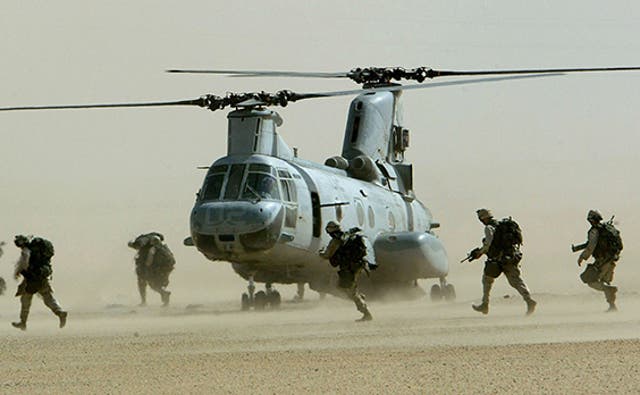 <p>U.S. marines from the 15th Marine Expeditionary Unit run in a line to a CH-46 Sea Knight
helicopter during a drill in the Kuwaiti desert near Iraq in this
February 23, 2003</p>