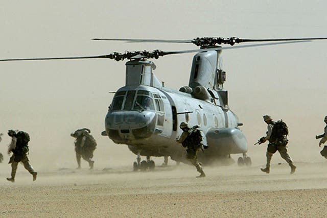 <p>U.S. marines from the 15th Marine Expeditionary Unit run in a line to a CH-46 Sea Knight
helicopter during a drill in the Kuwaiti desert near Iraq in this
February 23, 2003</p>