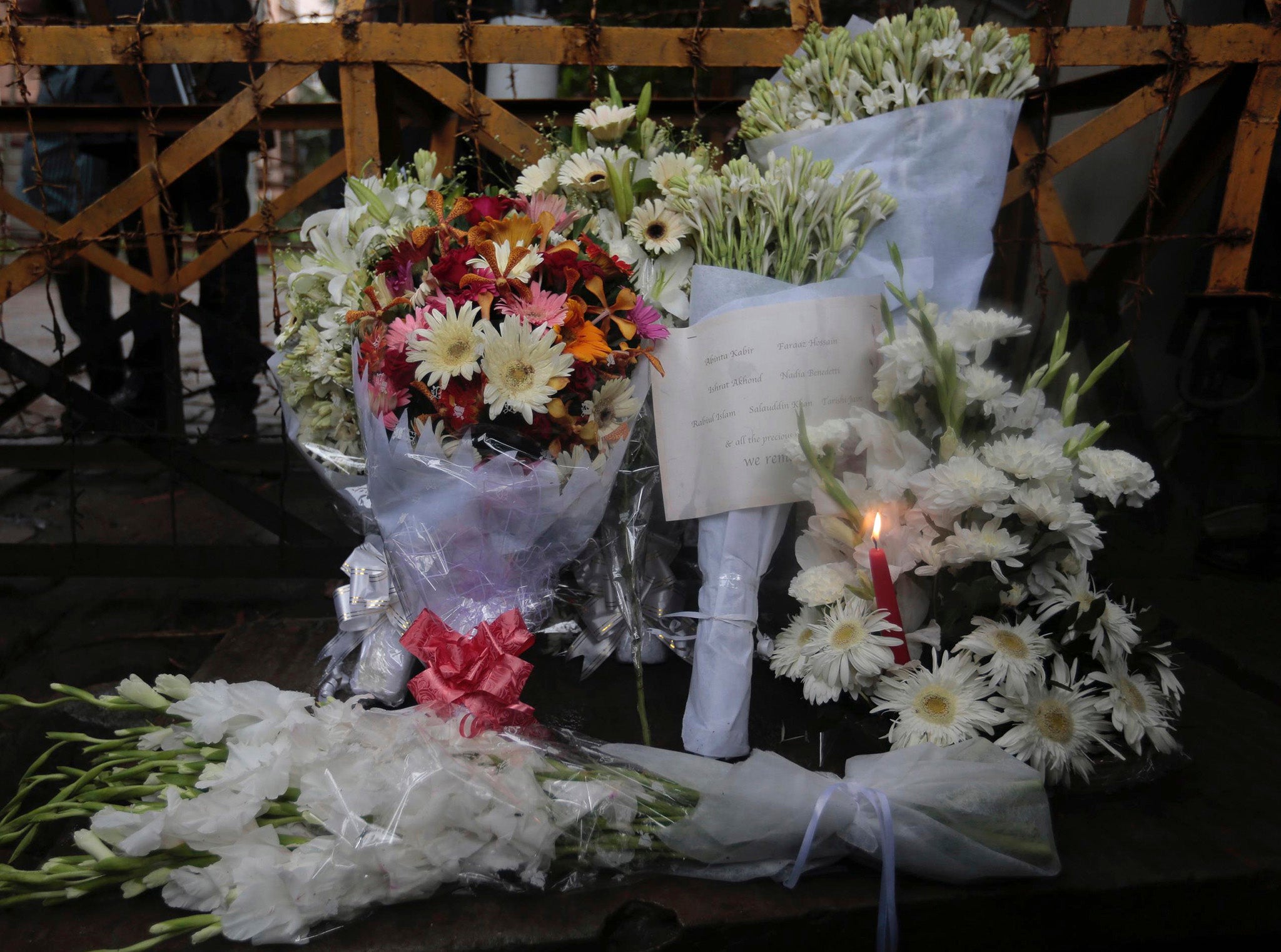 Flowers left at a barricade leading to the Holey Artisan Bakery to pay respects to the hostages who died there