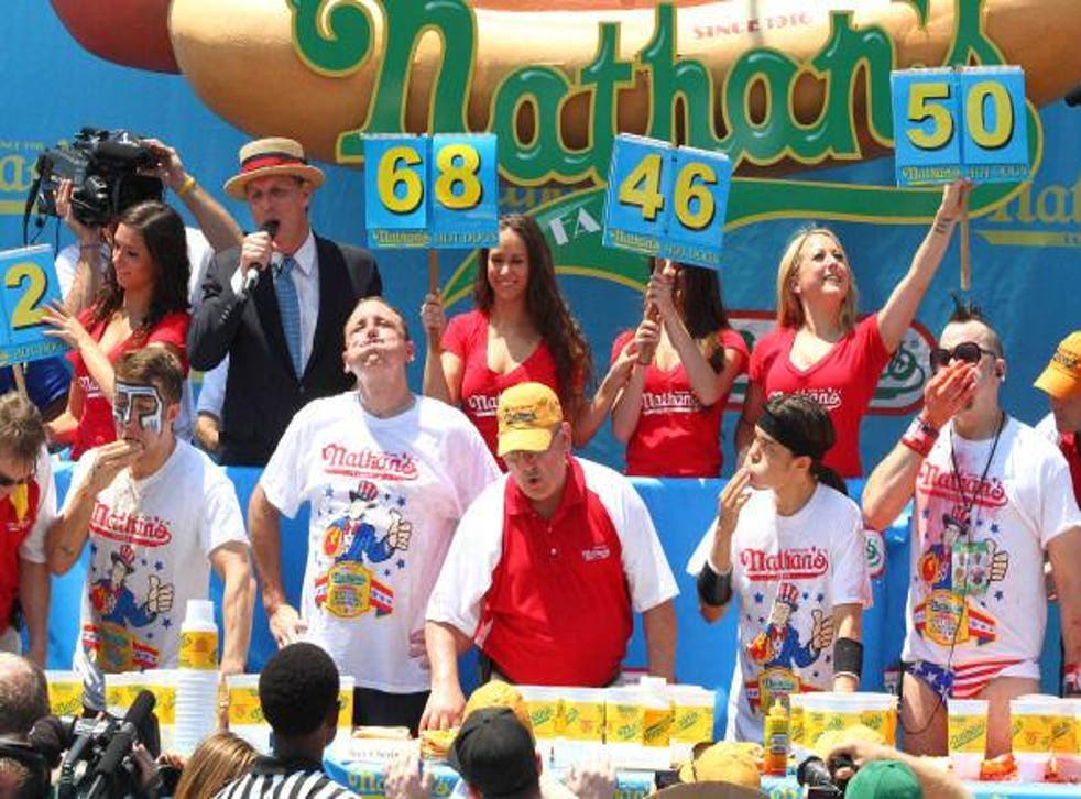 Joey Jaws Chestnut (second from left) takes a breath as he eats 68 hot dogs