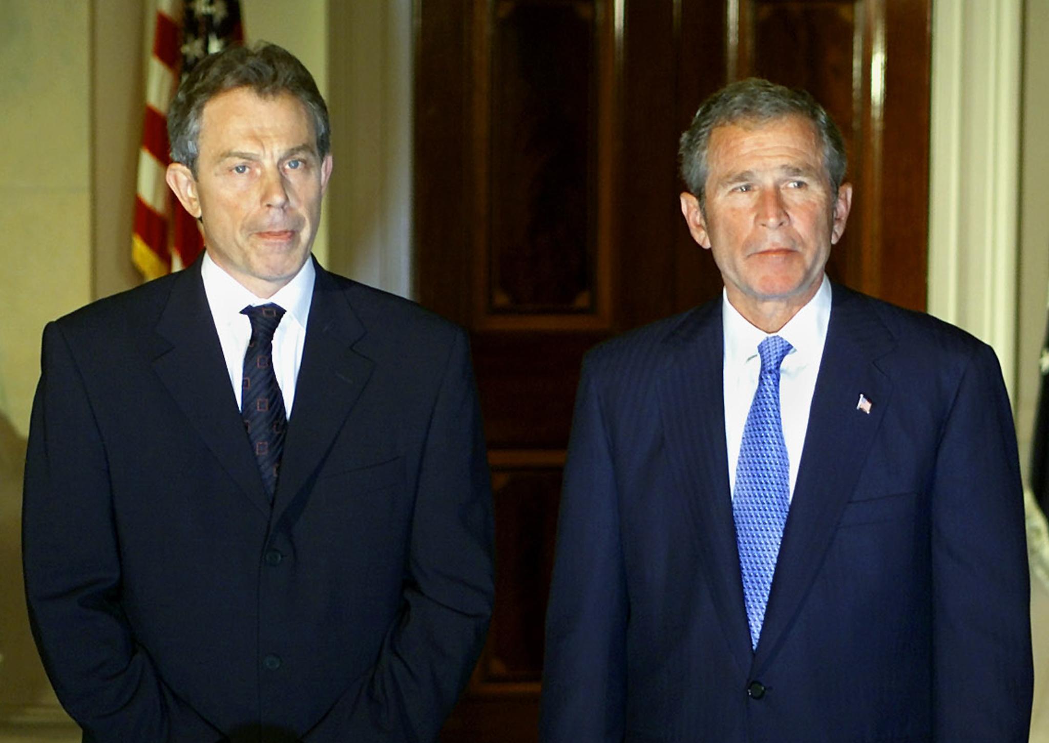 Tony Blair and US President George W Bush listen to questions from the US and British press as they meet at the White House late 20 September 2001