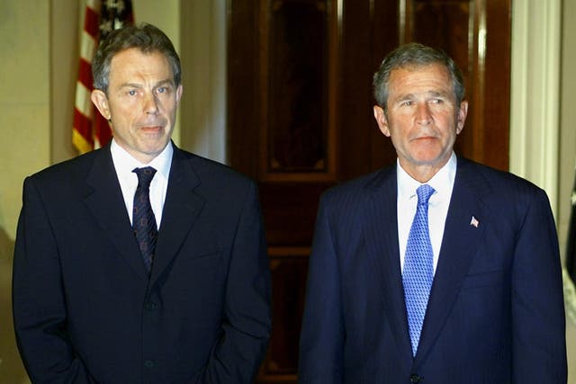 Tony Blair and US President George W Bush listen to questions from the US and British press as they meet at the White House late 20 September 2001