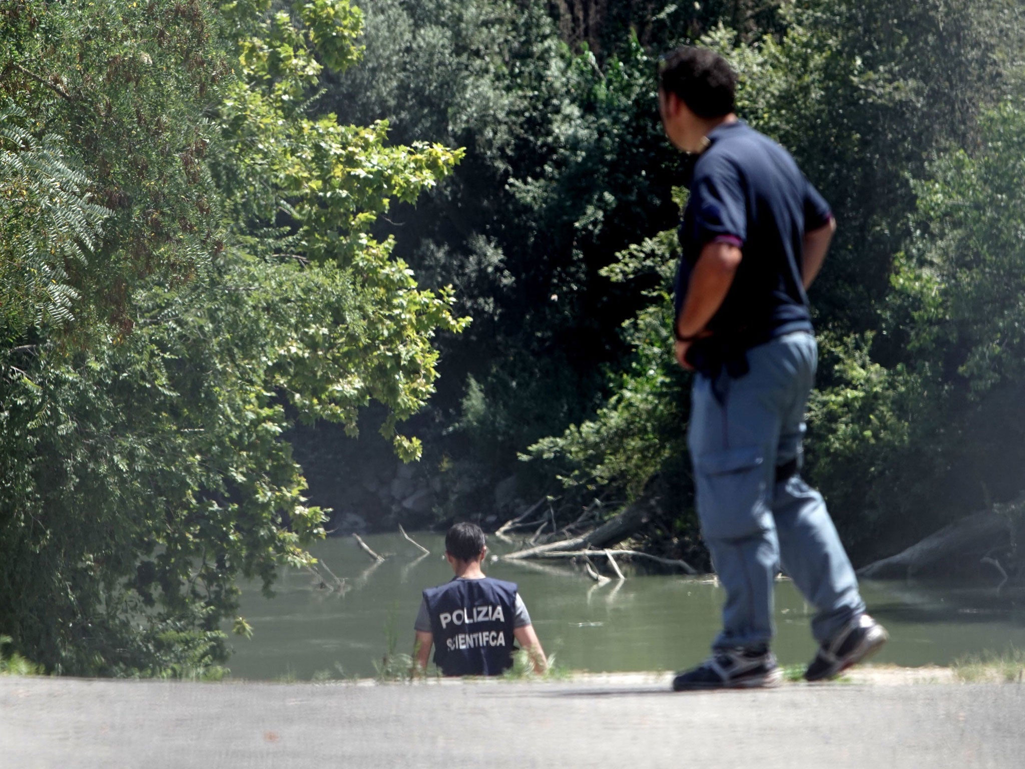 Italian police inspect the banks of the Tiber River, where the body of an American student was found