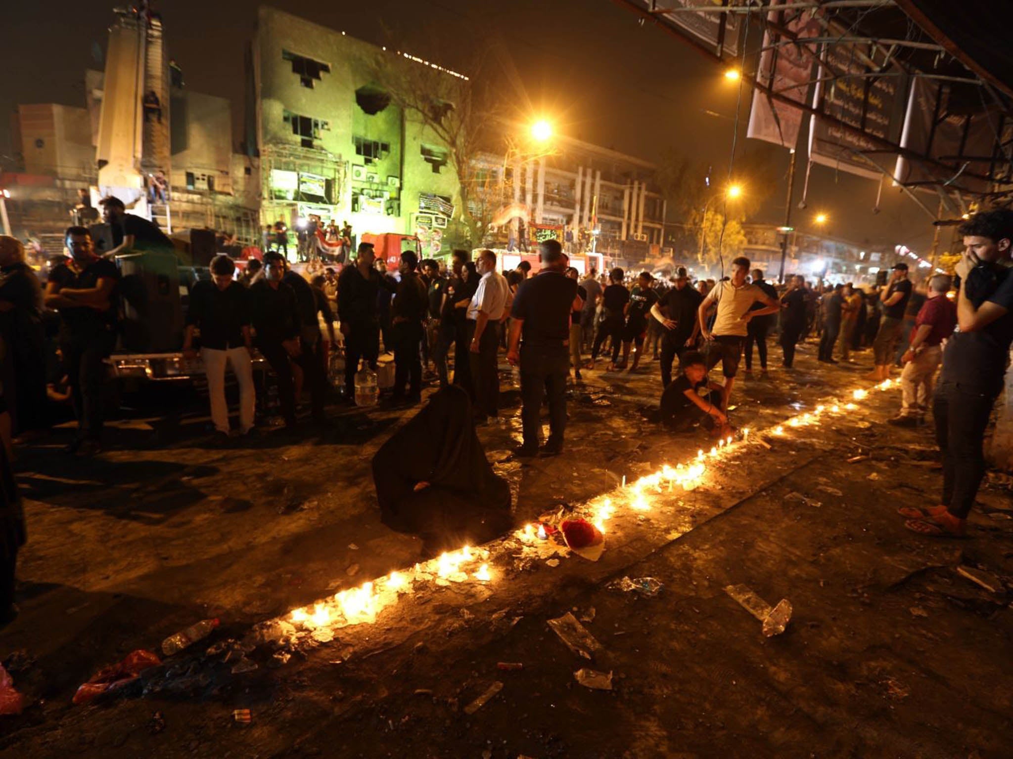 Following the death toll rising to more than 200, people light candles at the scene to remember those who died