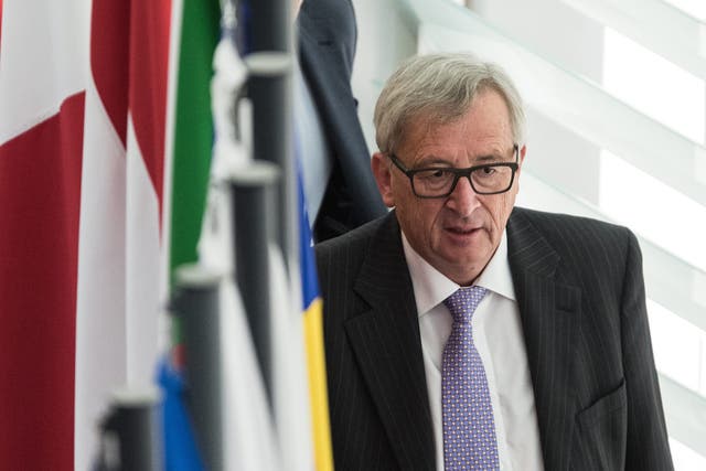 European Commission President Jean-Claude Juncker walks behind flags after a debate in the European Parliament in Strasbourg, France