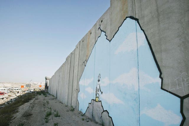 Graffiti titled 'Art Attack' made by the British guerrilla graffiti artist Banksy is seen on Israel's highly controversial West Bank barrier in Ramallah