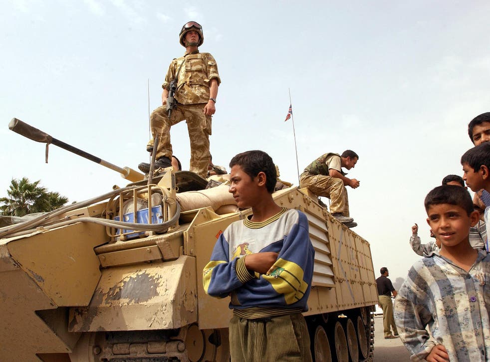 Children stand beside British troops after the troops occupied most of the strategic southern Iraqi city from Saddam Hussein loyalists, Basra, in 2003