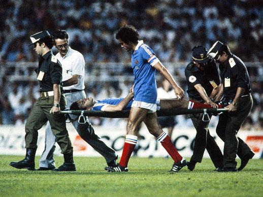 Patrick Battiston is taken from the field on a stretcher after the challenge from Toni Schumacher in 1982 (Getty)