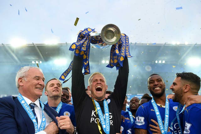 Kasper Schmeichel holds the Premier League trophy aloft as Leicester City are crowned champions