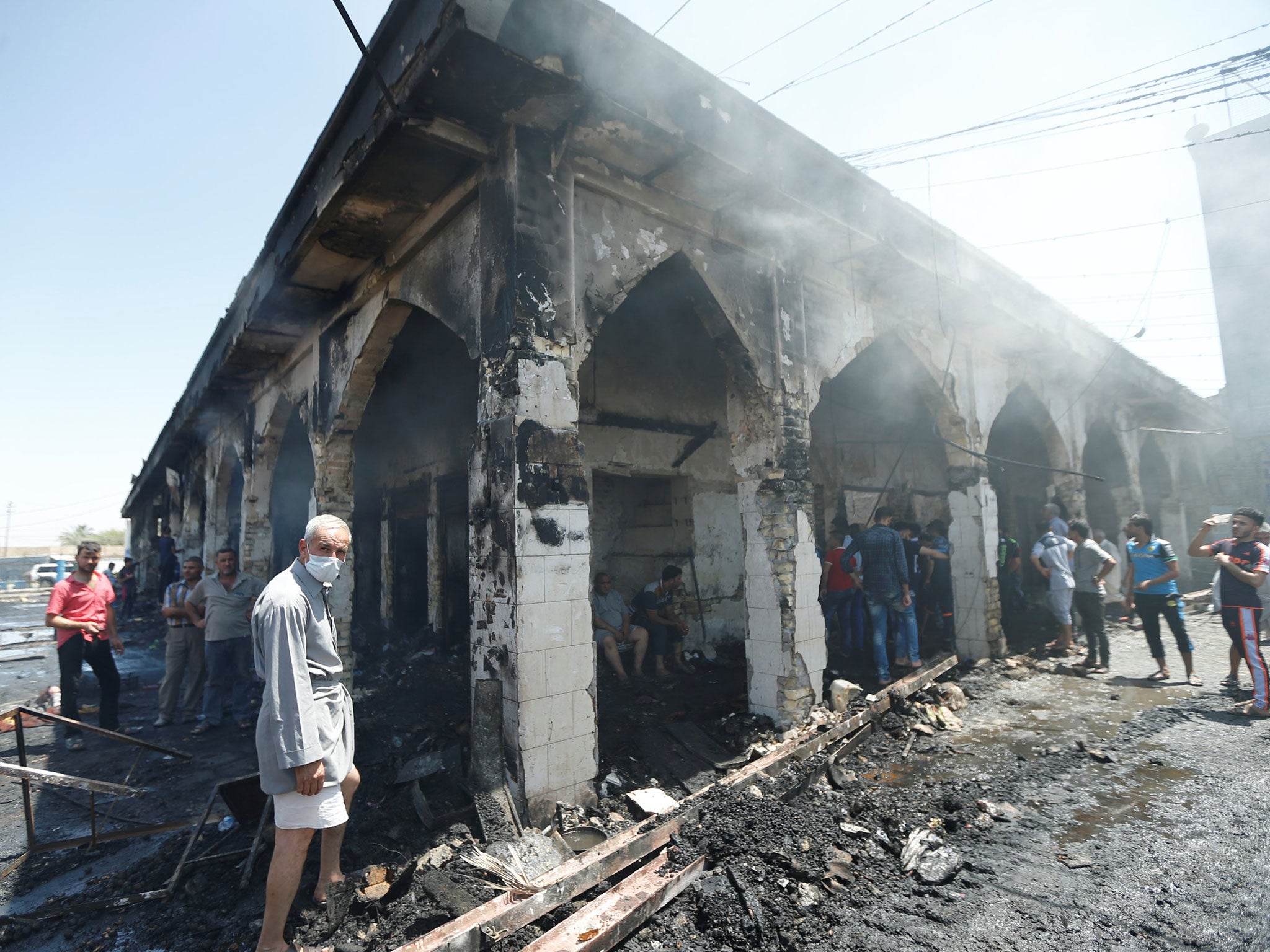 People gather at the site of a suicide attack at the entrance of the Shi'ite Mausoleum of Sayid Mohammed bin Ali al-Hadi in Balad, north of Baghdad, Iraq, July 8, 2016