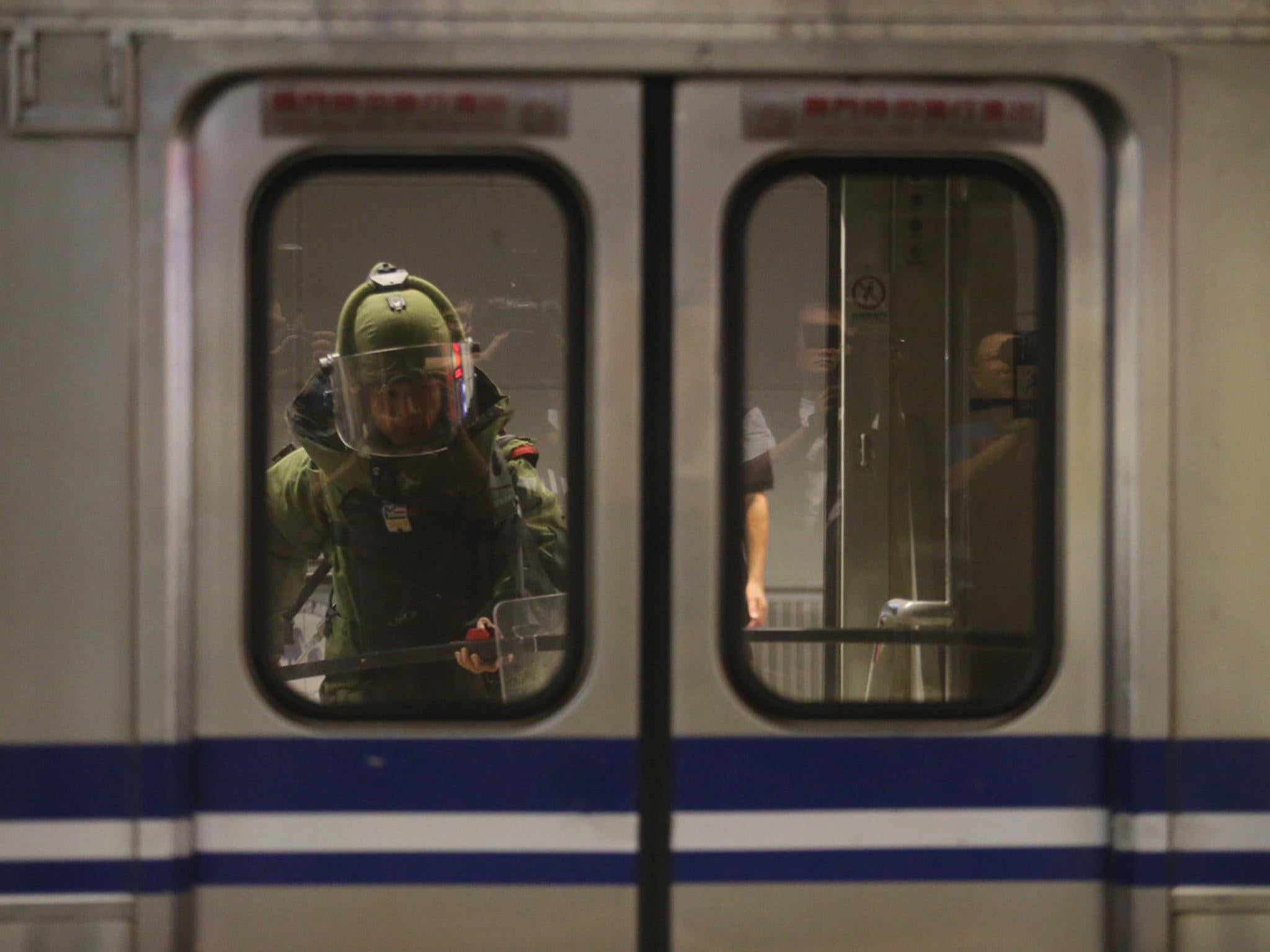 A bomb squad officer in protective gear enters the inside of a train carriage after the blast in Taipei