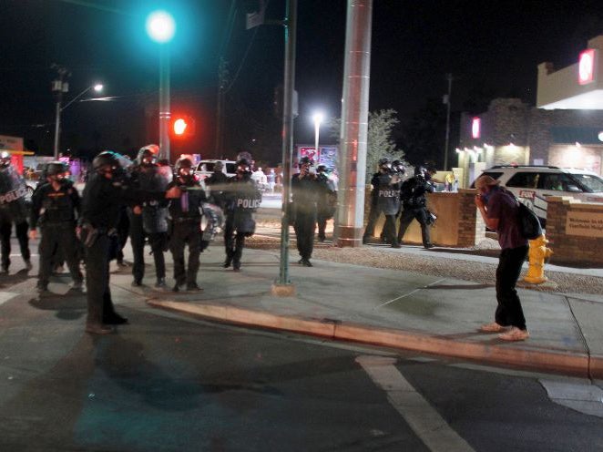 A police officer deploys pepper spray towards a protester at a demonstration in Phoenix, Arizona