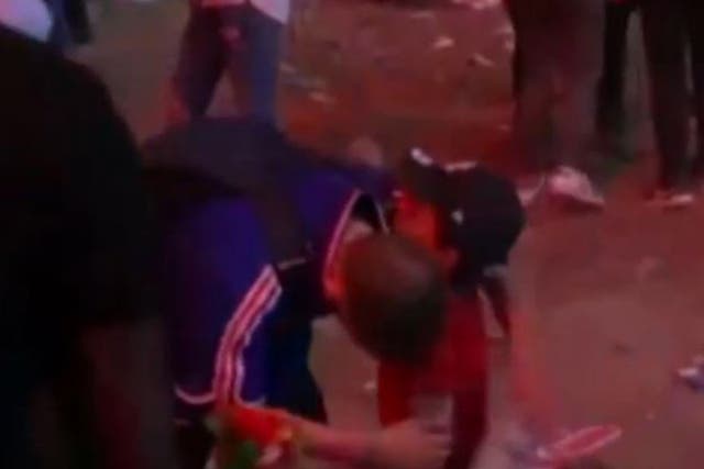 A France fan is consoled by a young Portuguese boy following the Euro 2016 final
