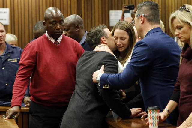 Aimee Pistorius cries as her brother is led to holding cells in Pretoria