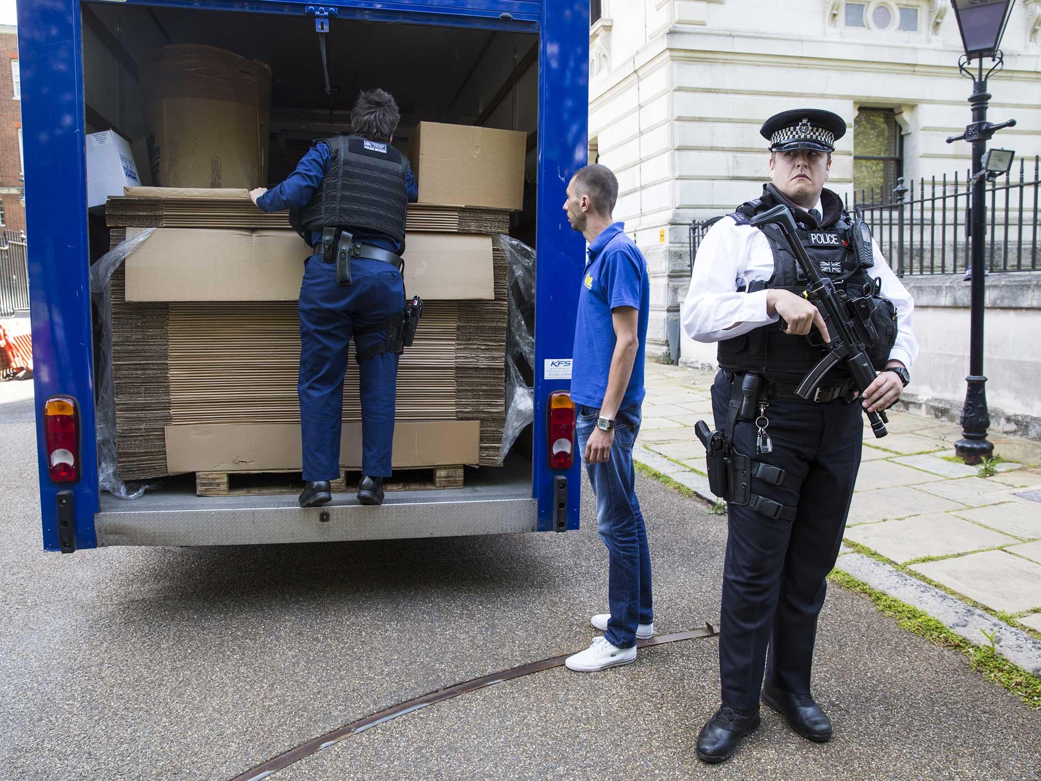 A removal van loaded with cardboard boxes is inspected by police before entering Downing Street