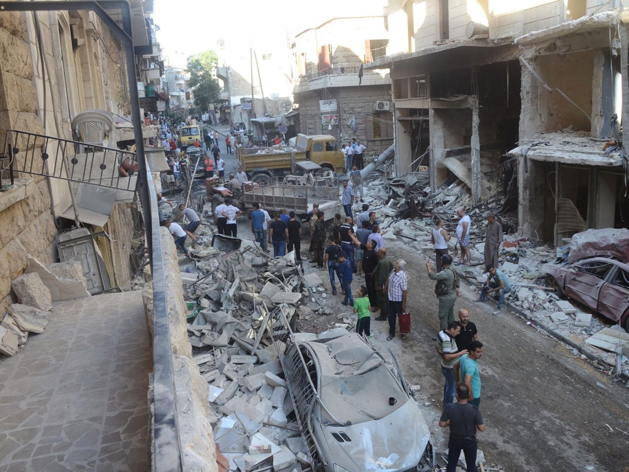 People inspecting a residential neighborhood after rocket shells attack, in the government-held area of Aleppo