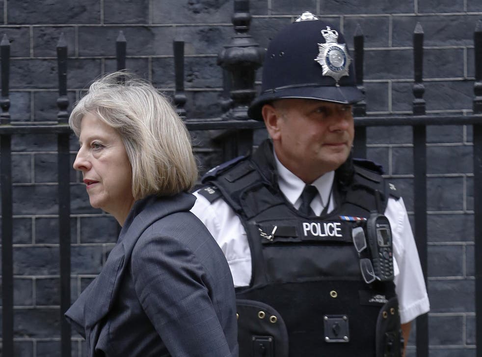 Britain's Home Secretary Theresa May passes a police officer as she arrives in Downing Street
