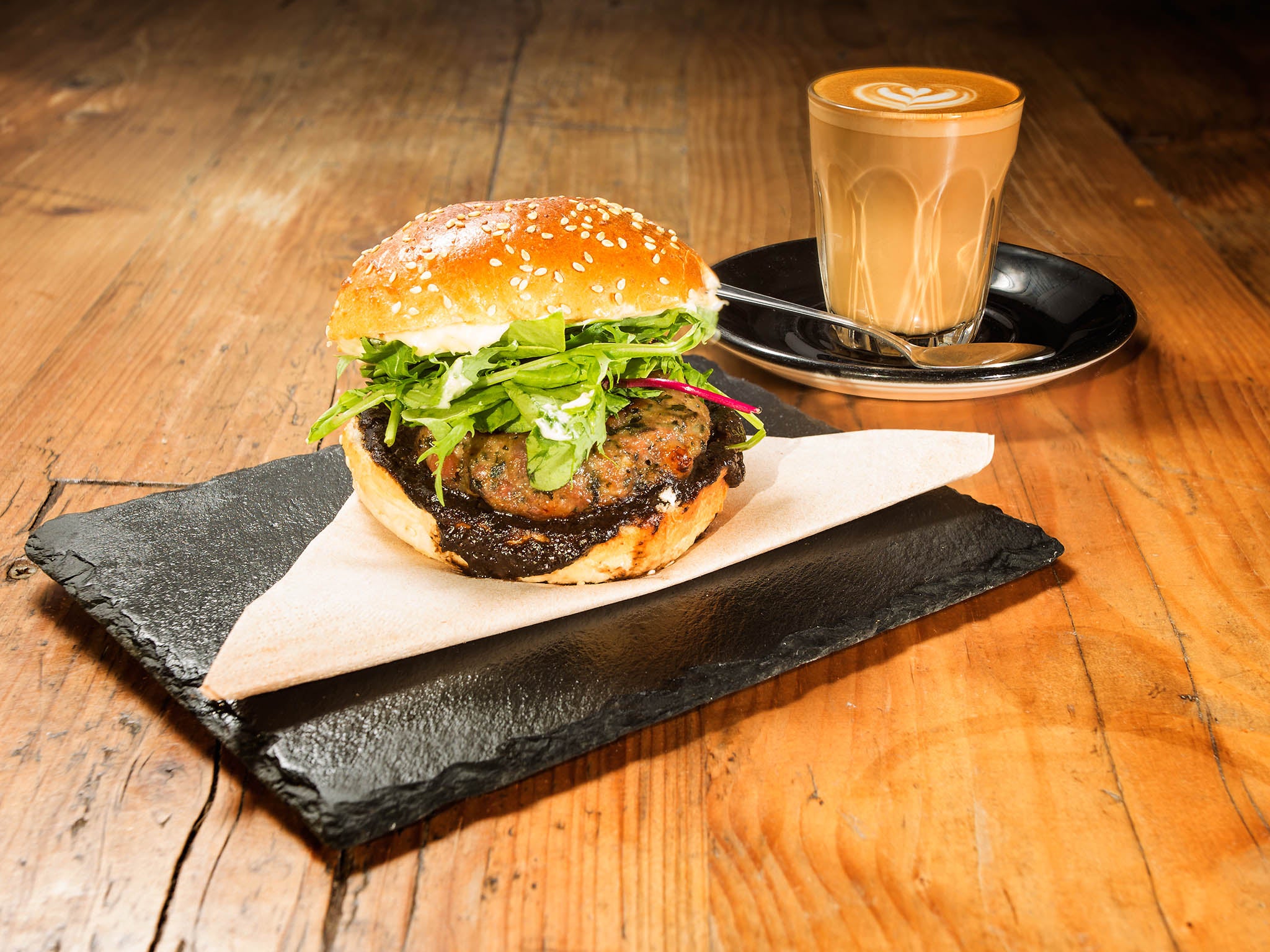 The sausage patty burger and a flat white made with Clifton Coffee