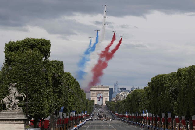 Alpha jets from the Patrouille de France fly in an 'Eiffel Tower' formation over the Champs Elysees during the traditional Bastille Day Military Parade in Paris