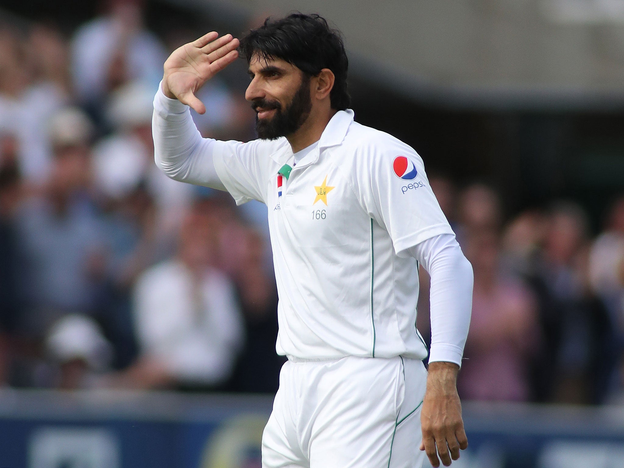 Misbah-ul-Haq salutes the Pakistan flag after reaching 100