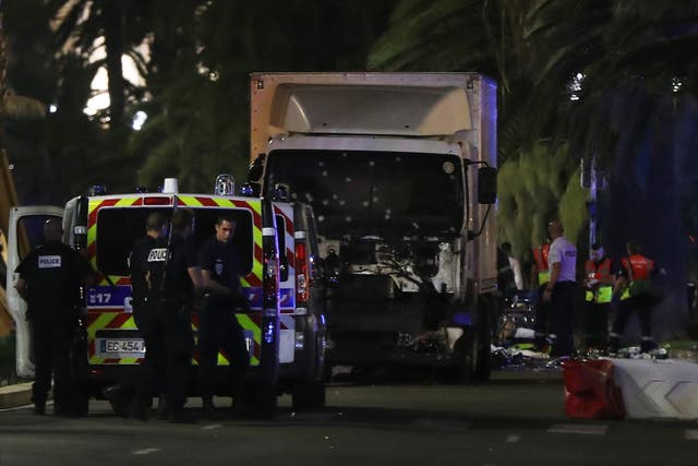 Police officers and rescue workers stand near a van that ploughed into a crowd leaving a fireworks display in the French Riviera town of Nice on July 14, 2016