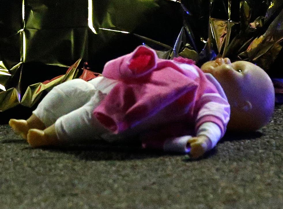 A doll lies next to the covered body of a girl killed when a lorry plunged into a crowd in Nice