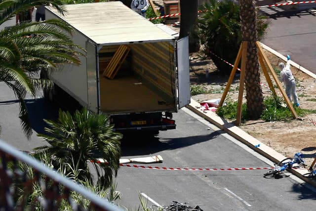 Police officers work near the truck that mowed through revelers in Nice