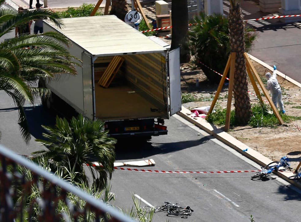 Police officers work near the truck that mowed through revelers in Nice