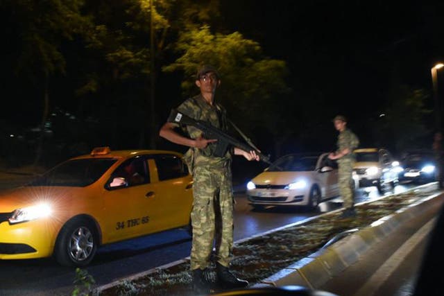 A Turkish security officer stands on guard on the side of the road