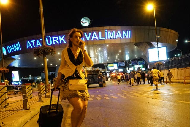 A passenger walks as Turkish army's tanks enter the Ataturk Airport on July 16, 2016 in Istanbul, Turkey.