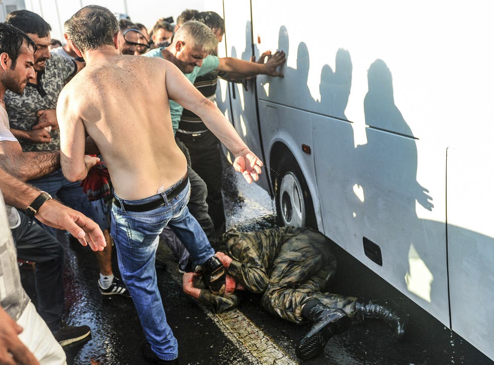 People kick and beat a Turkish soldier, who participated in the attempted coup, on Istanbul's Bosphorus Bridge