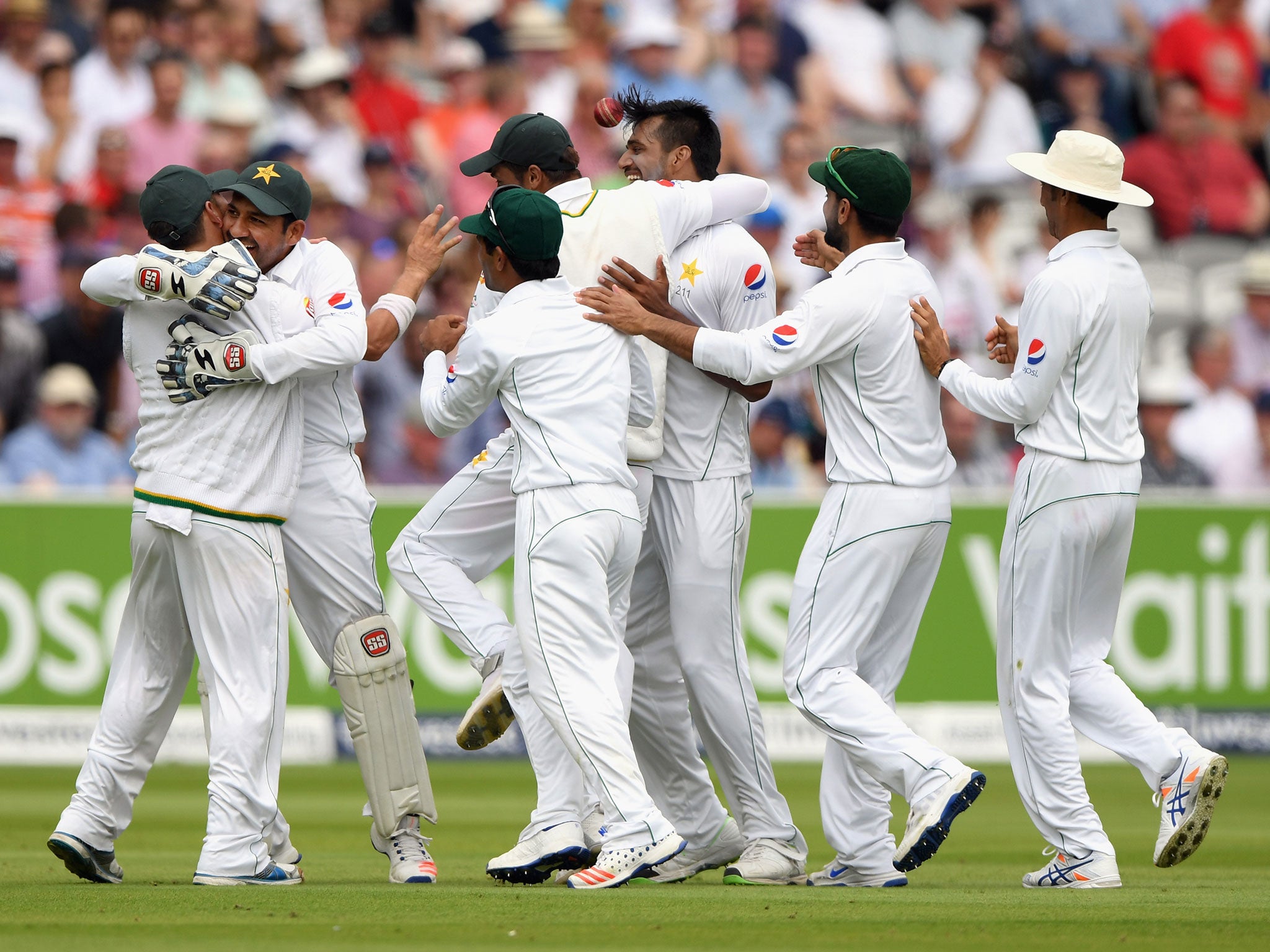 Yasir Shah is congratulated by team mates after Rahat Ali had combined to dismiss Joe Root