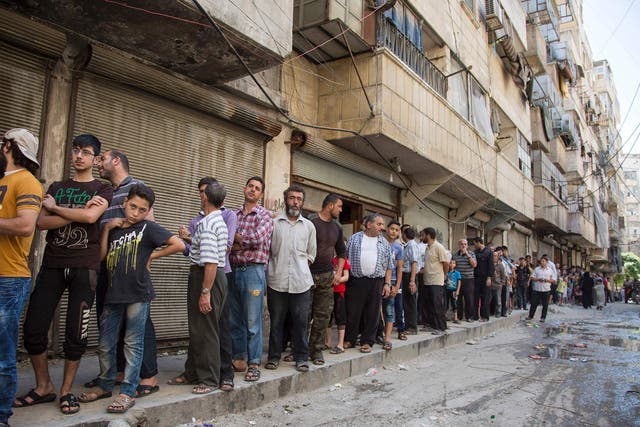 Syrians queue up to buy bread in a rebel held area of Aleppo on July 12, 2016.