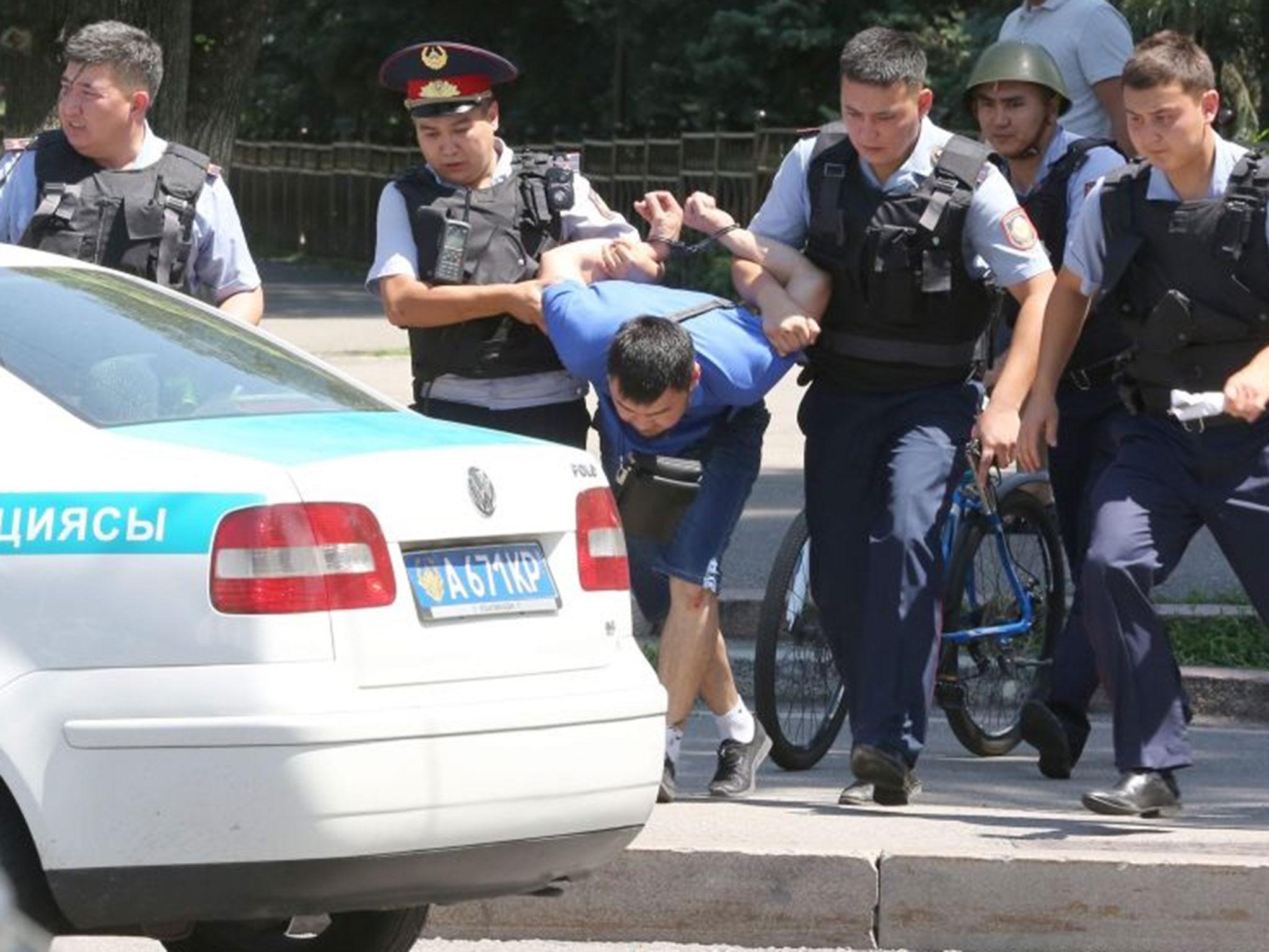 Kazakh policemen escort a detained suspect in armed attack of police station in Almaty, Kazakhstan, 18 July, 2016