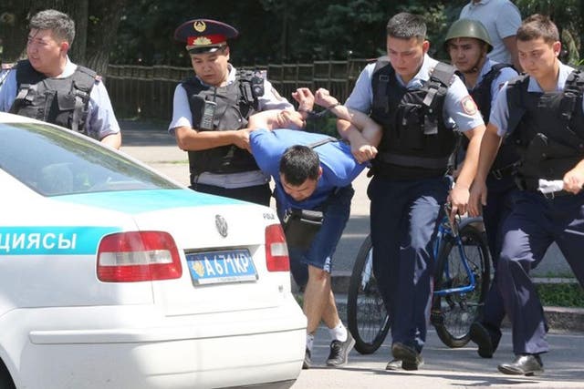Kazakh policemen escort a detained suspect in armed attack of police station in Almaty, Kazakhstan, 18 July, 2016