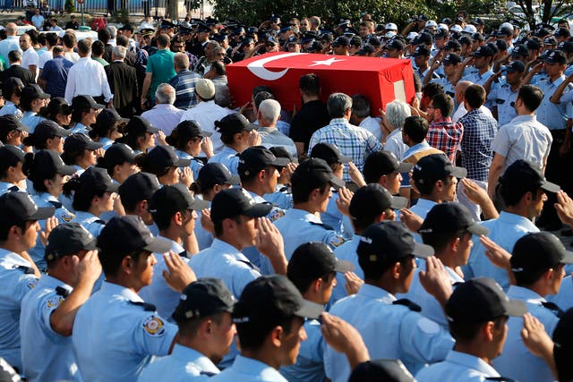 Turkish police salute as mourners carry the coffin of a police officer killed on Friday during the failed military coup