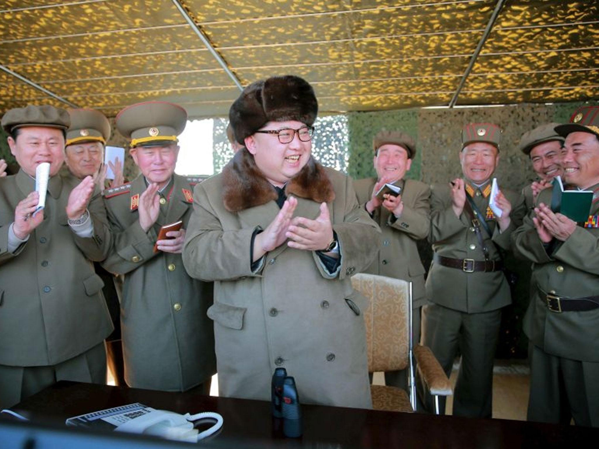 North Korean leader Kim Jong-un claps during a demonstration of a new large-caliber multiple rocket launching system at an unknown location, in this undated photo released by North Korea's Korean Central News Agency (KCNA) on 22 March, 2016