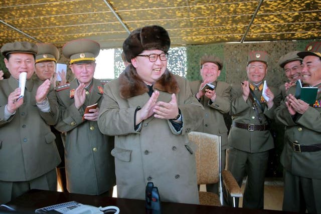 North Korean leader Kim Jong-un claps during a demonstration of a new large-caliber multiple rocket launching system at an unknown location, in this undated photo released by North Korea's Korean Central News Agency (KCNA) on 22 March, 2016