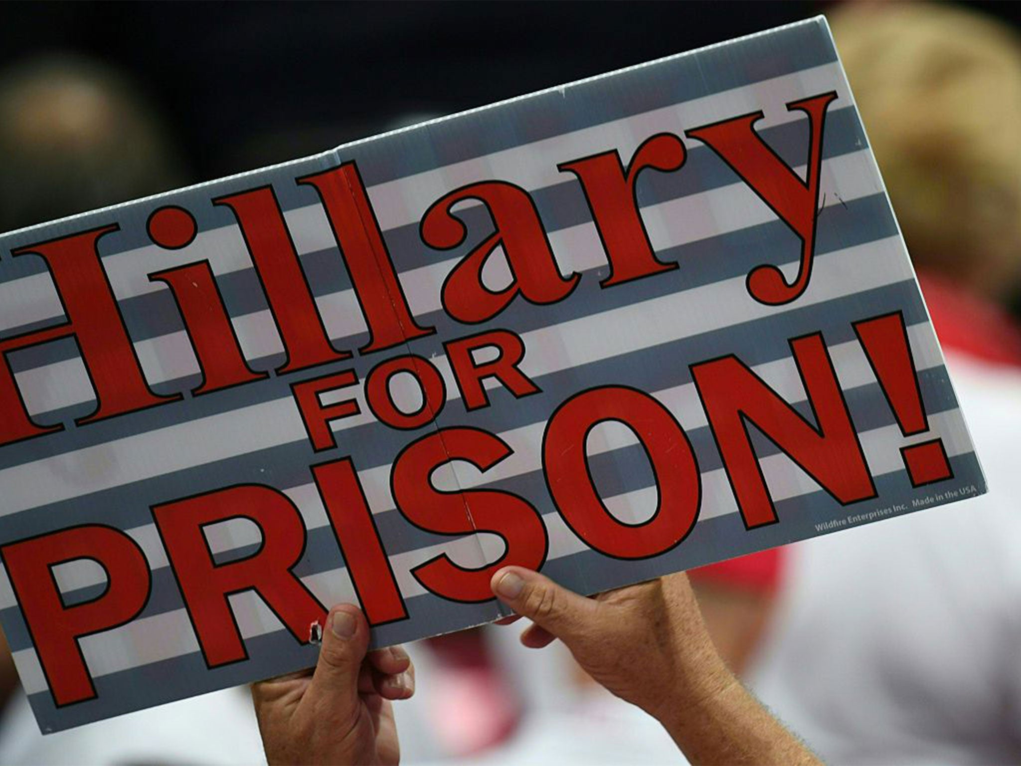 A sign against the Democratic presidential candidate Hillary Clinton is held aloft at the Republican convention yesterday