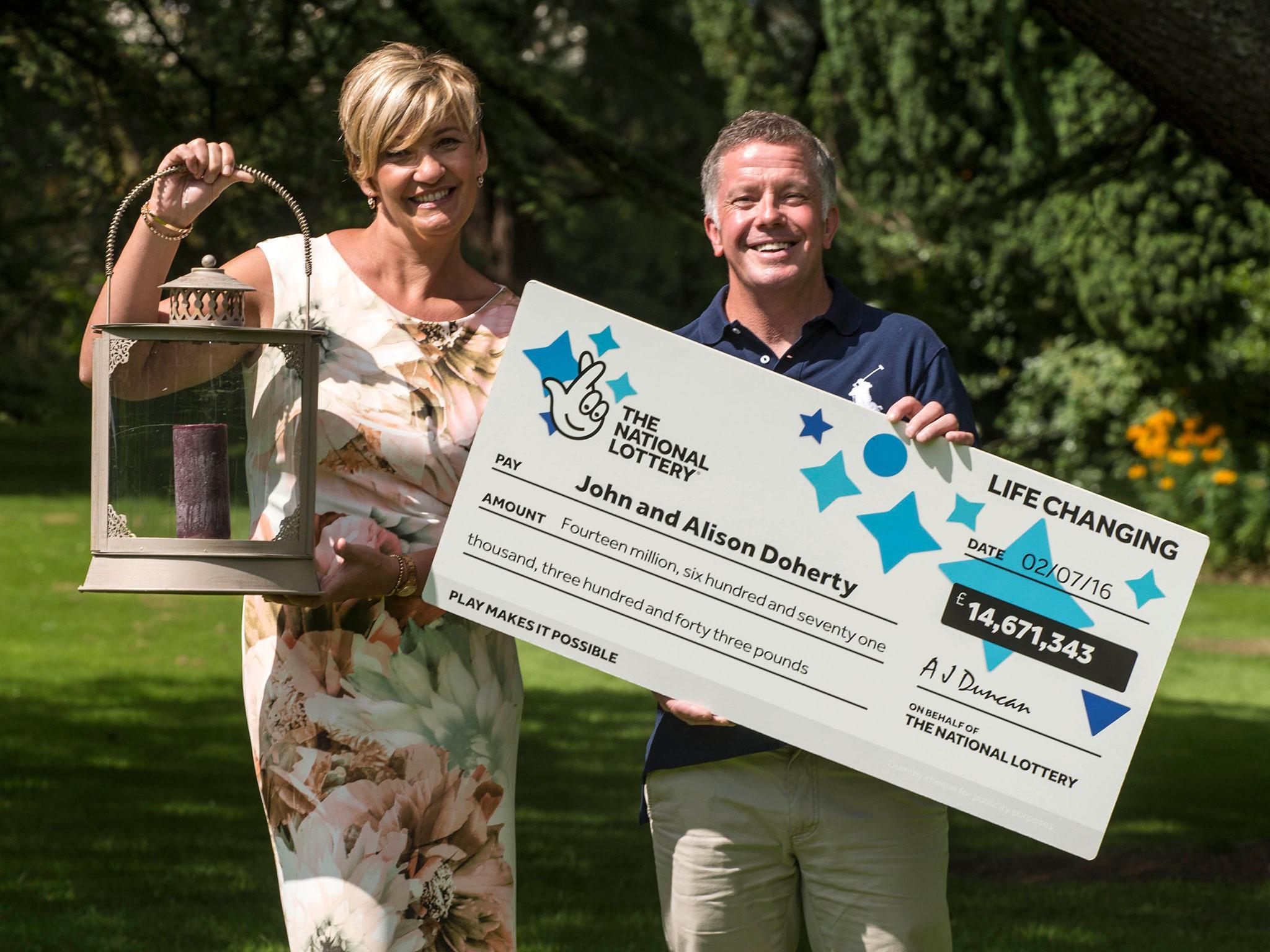 Alison and John Doherty with their lottery cheque and the lantern they hid the winning ticket inside when they went on holiday