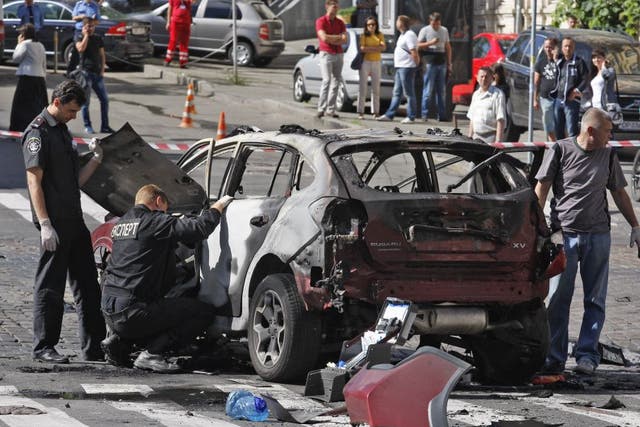 Police inspect the car of dead journalist Pavel Sheremet in Kiev