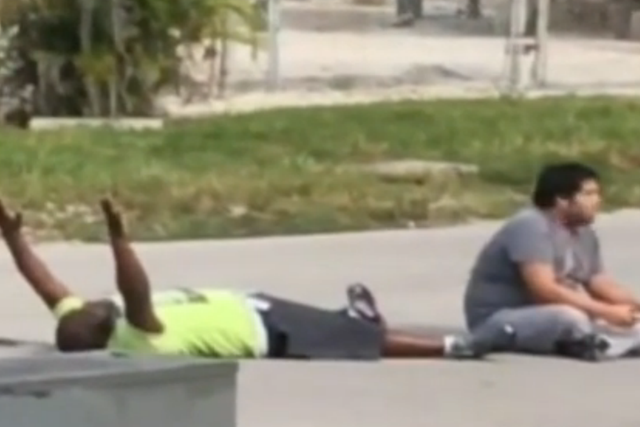 Behavioural therapist Charles Kinsey lies down with his hands up before police open fire on him