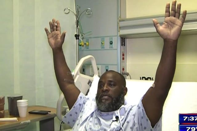 Charles Kinsey demonstrates how his hands were positioned in the moments before he was shot. He is now recovering in hospital